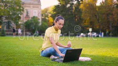 远程<strong>学习</strong>。 女孩坐在公园里，同时在电脑上看<strong>视频教程</strong>。 4K